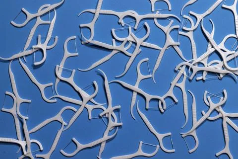 Image of white interdental toothpicks with a thread on a blue background ac.. Stock Photos