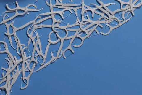 An image of white interdental toothpicks with a thread on a blue background.. Stock-Fotos