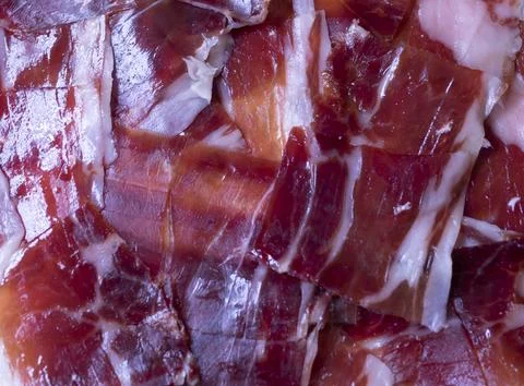 Image of a white plate with serrano ham on a black background Stock Photos