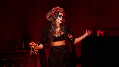 Image of witch Katrina with horns for All Saints Day in a dark room with bonfire Stock Footage 163361046