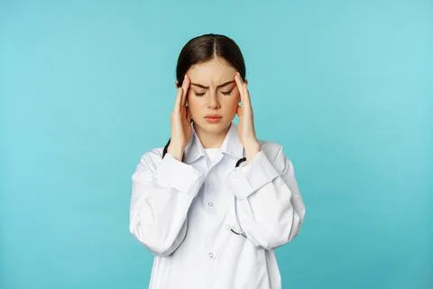 Image of woman doctor, medical personel grimacing from discomfort, having Stock Photos