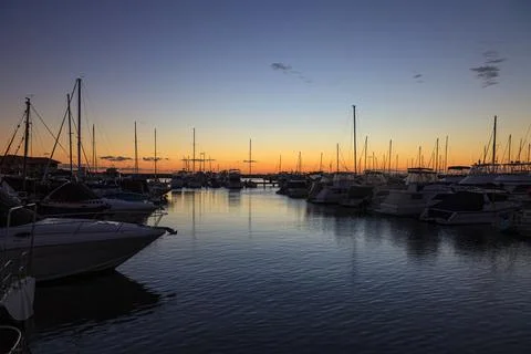 Image of yachts in marina after sunset with water reflections Stock Photos