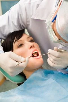 Image of young lady with dentist over her checking oral cavity Stock Photos