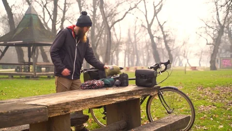 Image of young man packing to a bicycle touring trip in a park, Croatia. Video stock 127218700