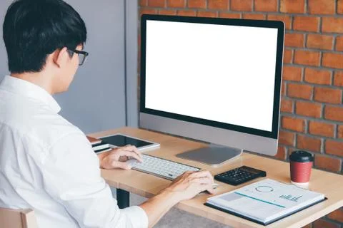 Image of Young man working in front of the computer laptop looking at screen Stock Photos