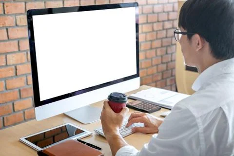 Image of Young man working in front of the computer laptop looking at screen Stock Photos