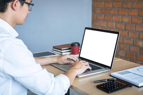Image of Young man working in front of the laptop looking at screen with a cl Stock Photos