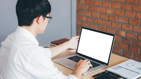 Image of Young man working in front of the laptop looking at screen with a cl Stock Photos