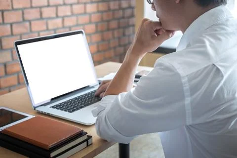 Image of Young man working in front of the laptop looking at screen with a cl Stock Photos