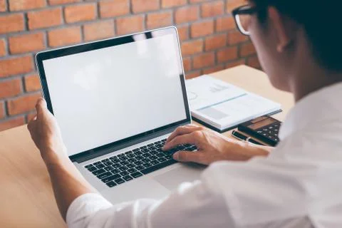 Image of Young man working in front of the laptop looking at screen with a cl Stock Photos