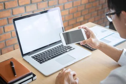 Image of Young man working in front of the laptop looking at screen with a cl Stock Photos