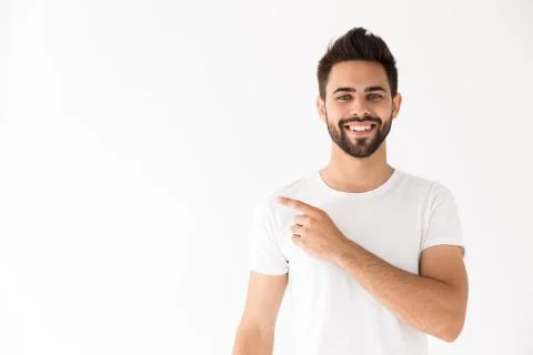 Image of young smiling man looking at camera and pointing finger aside at cop Stock Photos