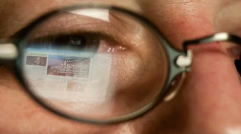 Images on the screen are reflected in the glasses of a man who works. Stock Footage 45642200