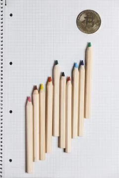 Imaginary bitcoin chart shown with color pencils on a white notebook. Stock Photos
