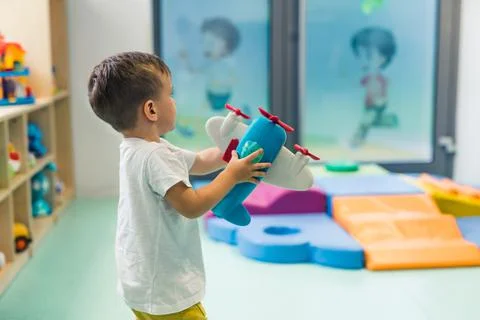 Imagination and creative thinking development. Toddler boy playing with a plane Stock Photos
