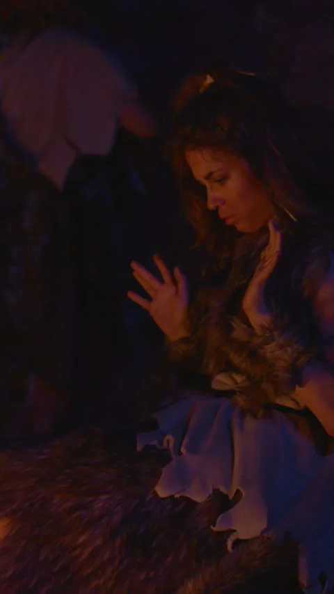 Imagine a caveman holding a smartphone while surrounded by a primitive and 動画素材 310815031