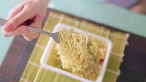 A imagine of a fork in the hands of someone indulging in fast food, Stock Footage 232959510