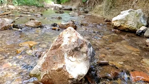 Imelapse big jasper stone in a river. Sunny changing into shadow Stock Footage 258308261