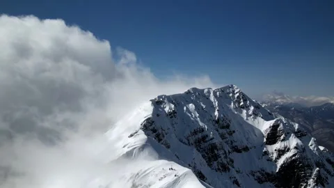 Imelapse clouds floating over the snow-capped peaks of the Caucasus mountains Video stock 256099877