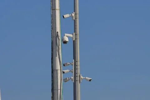 IMG 7389 Security camera on a lamppost against a blue sky background. Stock Photos