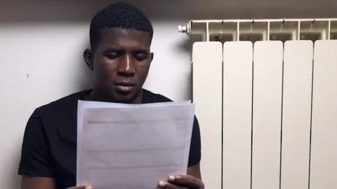 Imigration, problems -black man read the resdidence aplication form discouraged Stock Footage 240322031