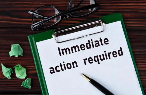 IMMEDIATE ACTION REQUIRED - words on a white sheet on a brown wooden backgr.. Stock Photos
