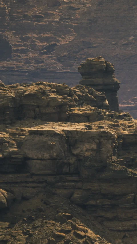 Immense rock formations rise majestically under the golden sun rays Stock Footage 341392312