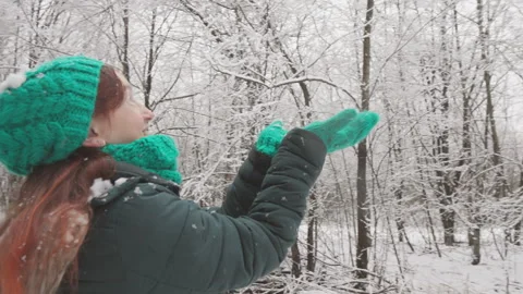 Immerse yourself in a tranquil winter scene with a serene woman in a green hat Stock Footage 283207804