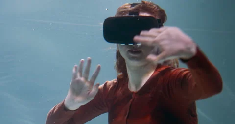 Immersed in virtual reality. Young beautiful smiling redhead woman using VR Stock Footage 153781741