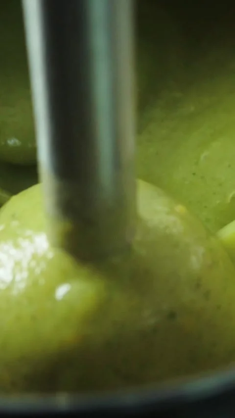 Immersion blender mixing green vegetable soup cream puree Video stock 346397034