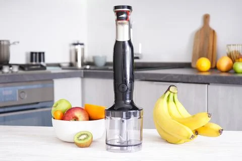 Immersion hand blender on table on a kitchen background. Electric hand mixer. Stock Photos