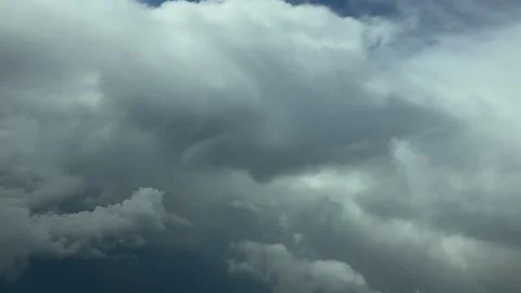 An Immersive Cockpit View of Flight Through Dramatic Storm Clouds Under a Blue Video stock 310764606