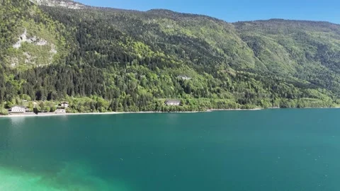 Immersive Drone Tracking Shot Over Vibrant Turquoise Lake Waters in the Vídeo Stock 337695549