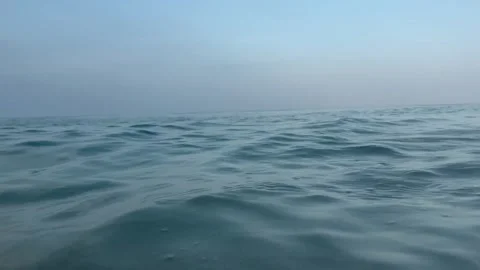 Immersive ocean level view with approaching waves and raindrops on sea surface Video stock 337411895