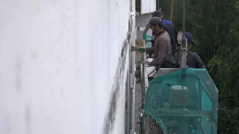 Immigrant Facade Crew Repairs Wall From Suspended Platform Stock Footage 345776186