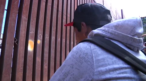 Immigrant looking to border wall Stock Footage 40797064