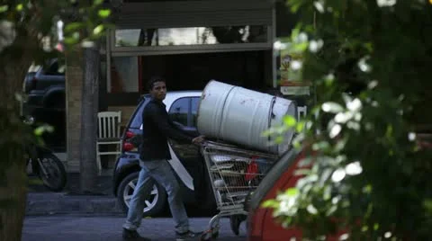 Immigrant pulling barrel on cart Video stock 12577015