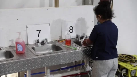 Immigrant washing up a sink at temporary processing facility in Donna, Texas Stock-Footage 151251747