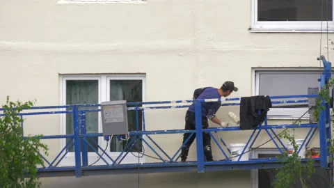 An immigrant worker covers the wall with white paint Stock Footage 134740041