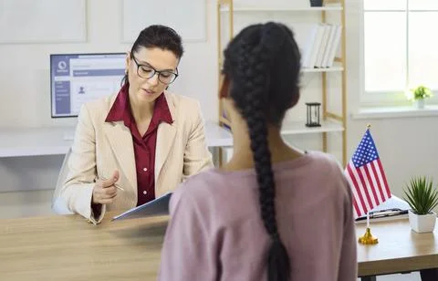 Immigration consultant interviewing client about visa documents in office with Foto stock