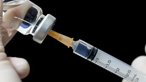 Immunization Closeup of syringe drawing medicine from a bottle Covid-19 Stock-Footage 336587344
