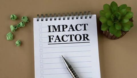 IMPACT FACTOR - words on a white notebook against the background of a cactus  Stock Photos
