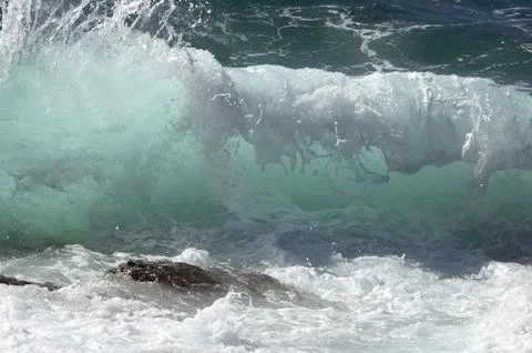 Impact of large waves against rocks in the beach Stock Photos