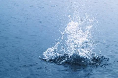 Impact splash on water surface Stock Photos