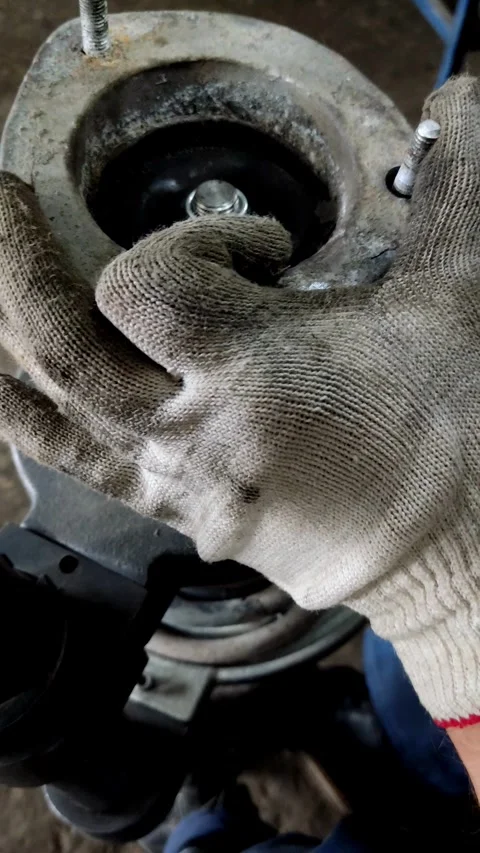 An impact wrench tightens a top nut on car strut Stock Footage 335834631
