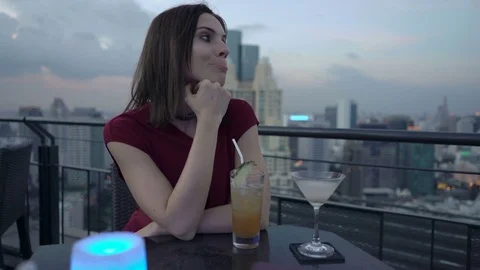 Impatient woman waiting for someone in bar, checking phone and drinking cocktail Stock Footage