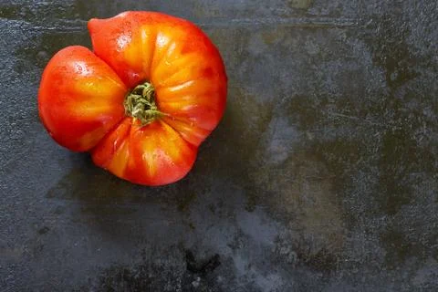 Imperfect tomato on rustic background Stock Photos