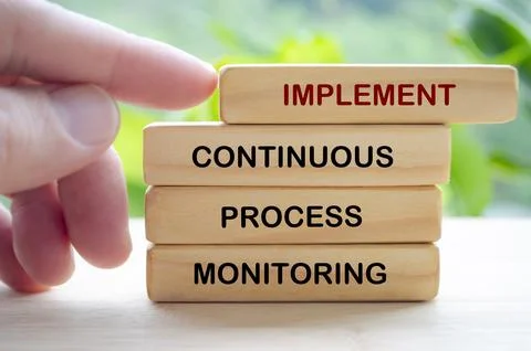 Implement Continuous Process Monitoring text on wooden blocks representing .. Stock Photos
