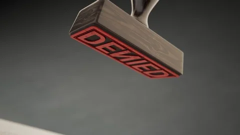 An important document being denied by red office stamp in slow motion. 4KHD Stock Footage 119981490