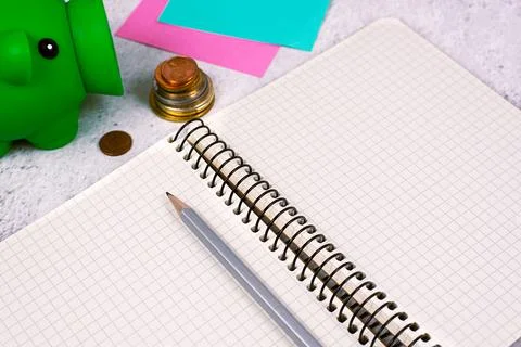 Important Message On Notebook On Desk With Money, Pen, Notes And Pig Box Stockfoto's